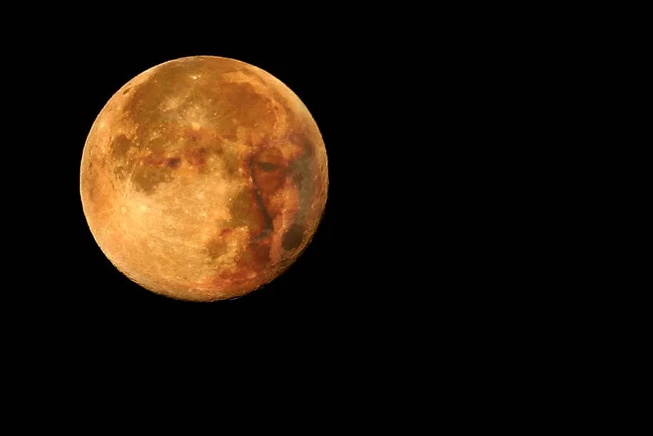 Fotografie eines fast vollen Mondes, orange bis ockerfarben, mit deutlich sichtbaren Kratern und dunklen Flecken, freigestellt vor vollständig schwarzem Himmel.