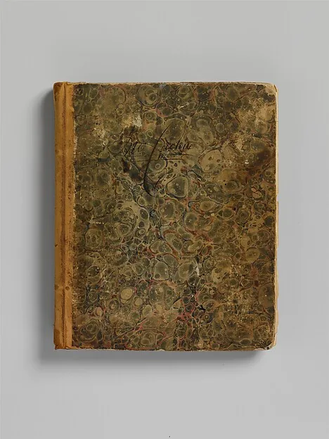 Abgegriffenes Buch mit marmoriertem grün-braunem Deckel und hellem Lederrücken, auf dem Deckel ein verblasstes handschriftliches Wort.