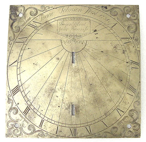 Quadratische Messingplatte mit eingravierter Sonnenuhr: ein Ring aus römischen Ziffern, ein Fächer aus Strahlen zur Mitte, in den Ecken Rankenornamente; oben eine gravierte Namenszeile und in einem Kästchen die Zeilen „Begon About your Business“ und „NEW YORK“.