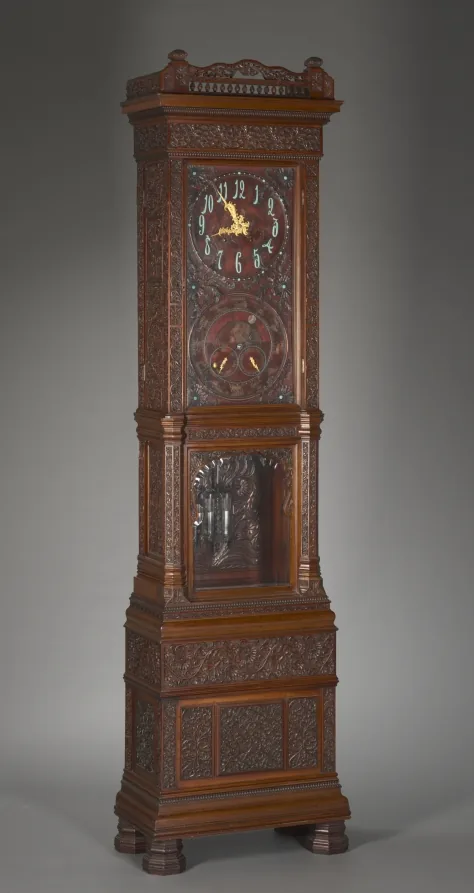 Hohe Standuhr aus Holz mit Zifferblatt im Kopf.