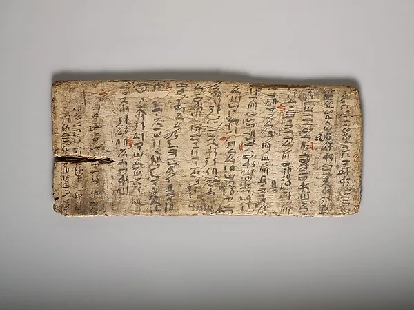Hölzerne Schreibtafel, dicht beschrieben mit Zeilen ägyptischer Schriftzeichen in schwarzer und roter Tinte.